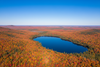 Vue panoramique sur une forêt canadienne en automne avec lac, flambée de couleurs rouge, orange et or