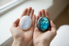 Galet palmier pierre de lune et labradorite tenus dans les mains — lithothérapie O'NAIA